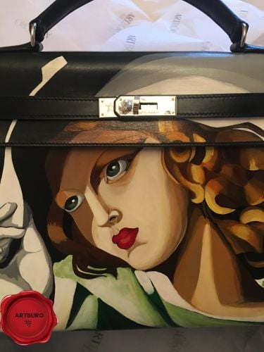 ARTBURO Personalization : Hand Painted HERMÈS Vintage Kelly Bag, Girl in Green with Gloves by Tamara de Lempicka, (1929). "Art Deco Collection by ARTBURO" for Angelika Ivanc.  АРТБЮРО Персонализация : Ручная Роспись HERMÈS Vintage Kelly Bag, Девушка с перчатками Тамара де Лемпицка, (1929). Коллекция АРТБЮРО "Арт-Деко". Exceptional HERMÈS bag.  Artist:Tamara De Lempicka Created:1931 Dimensions (cm):45.5 x 61.5 Format:Oil on plywood Location:Musée national d'art moderne, Paris, France   Perhaps Tamara De Lempicka’s most famous painting, ‘Girl in Green with Gloves’, has been an icon to her artistic style and work throughout her career. Painted in 1929, the ‘Girl in Green with Gloves’ displays a beautiful young woman wearing a flimsy green dress, white gloves, and a large, white hat. The sharp-edged form combined with the bold use of color render the whole strongly dimensional and modern. It appears that the sleek feminine figure with curvaceous lines is holding on to her hat in order to avoid losing it in the breeze, De Lempicka undoubtedly masters the effect of a wind blowing through the painting. A slight sense of eroticism is established by having the dress cling to her body, revealing her breasts and navel through the fabric.