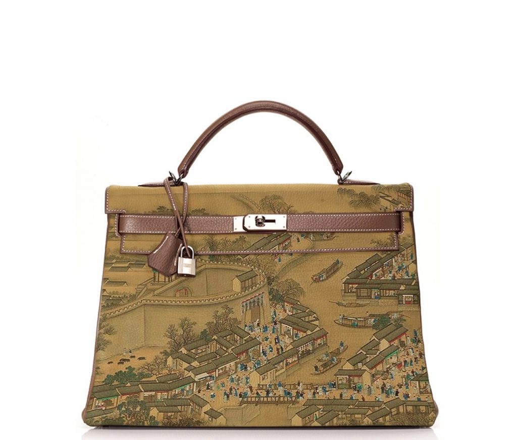 A luxury handbag with a detailed traditional East Asian landscape painting design.