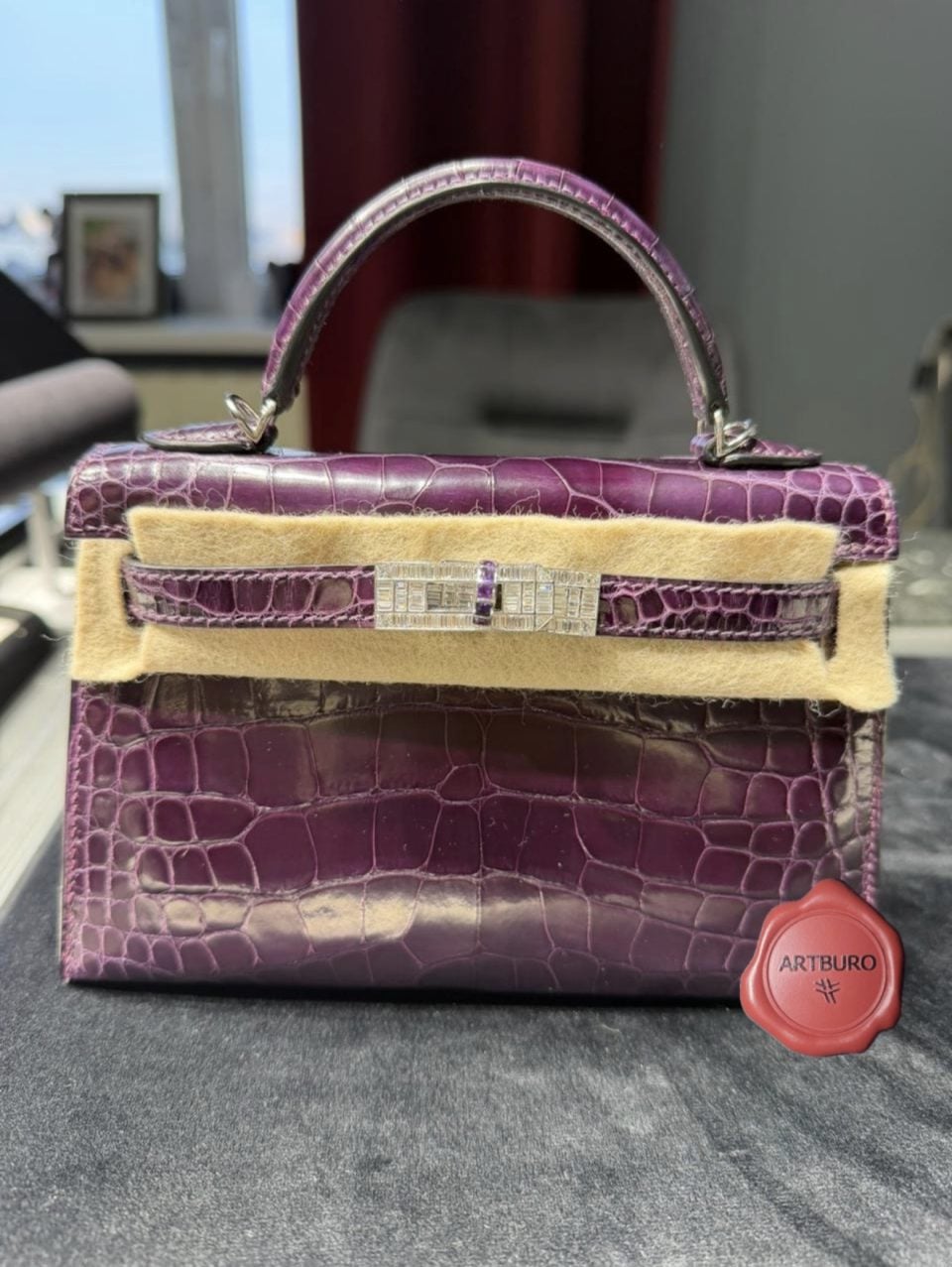 AMETHYST
Fashion is Art.
Some objects are worn.
Some are collected.
Some become part of history.
AMETHYST exists beyond the rhythm of seasonal fashion. It was created as a permanent object of desire—where the discipline of haute maroquinerie meets the precision of high jewellery.
The iconic Hermès Kelly 20 Sellier Mini becomes a canvas for contemporary craftsmanship, transformed through bespoke 18K white gold hardware, invisible engineering and hand-set baguette diamonds. At its heart, a natural amethyst serves as the soul of the composition—quiet, powerful and unmistakable.
Every line was considered.
Every surface refined.
Every detail created to be remembered.
This is not personalization.
This is artistic authorship.
Not made for everyone.
Made for the few who understand that true luxury is defined not by price, but by rarity, provenance and meaning.
A collectible object.
A wearable sculpture.
An archive piece for the future.
⸻
The Diamond Hermès Kelly 20 Sellier Mini Shiny Alligator
Bespoke 18K White Gold Hardware
Baguette Diamonds & Natural Amethyst
Created by ARTBURO
Designed by Alisa Kovtunova
2025